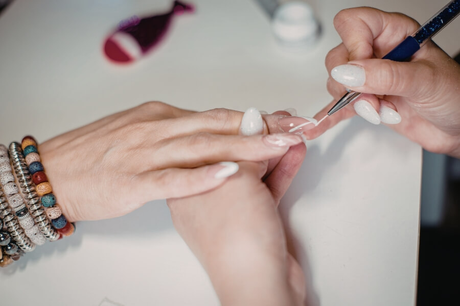 Kỹ thuật viên dùng cọ để thực hiện vẽ móng chi tiết tỉ mỉ từng ngón