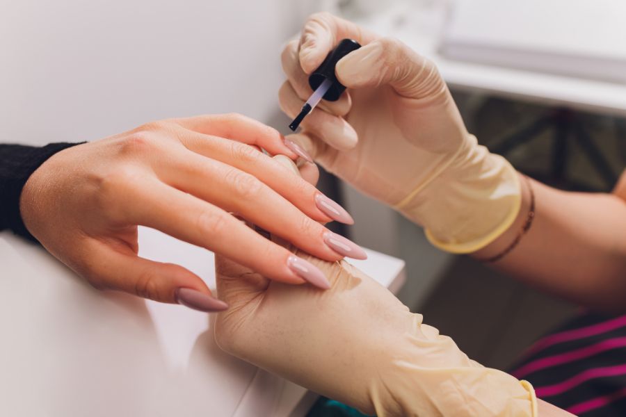 Kỹ thuật viên tỉ mỉ sơn gel và hơ đèn, giúp lớp sơn lên màu chuẩn và bền đẹp