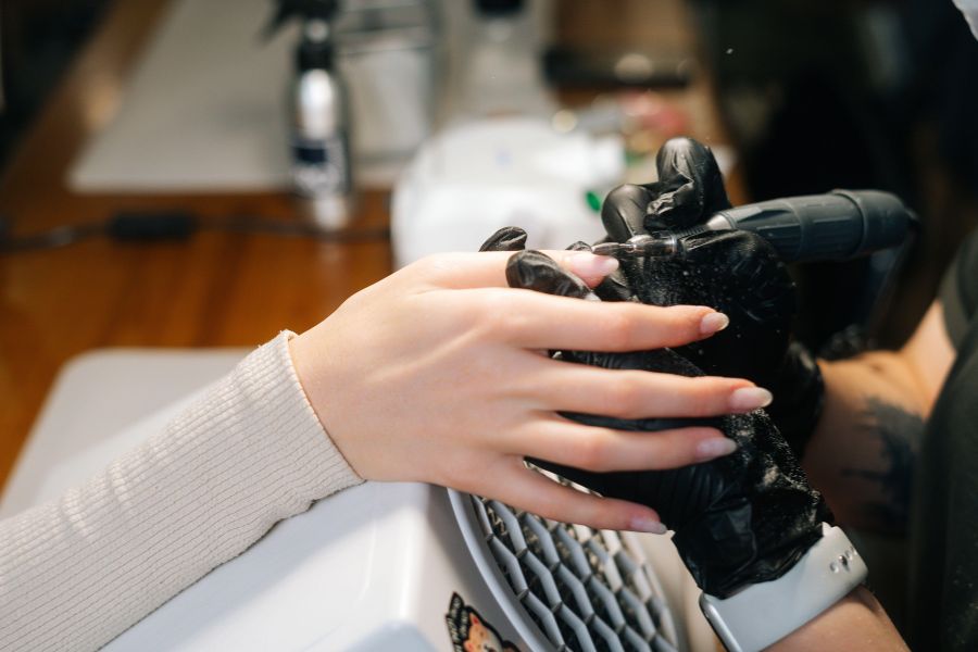 Sử dụng máy mài chuyên dụng phá lớp sơn top giúp dung dịch tháo móng dễ thấm sâu